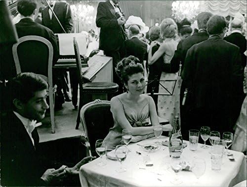 Реколта снимка на принцеса Иран Сорайи на партито, седи, гледа в камерата.